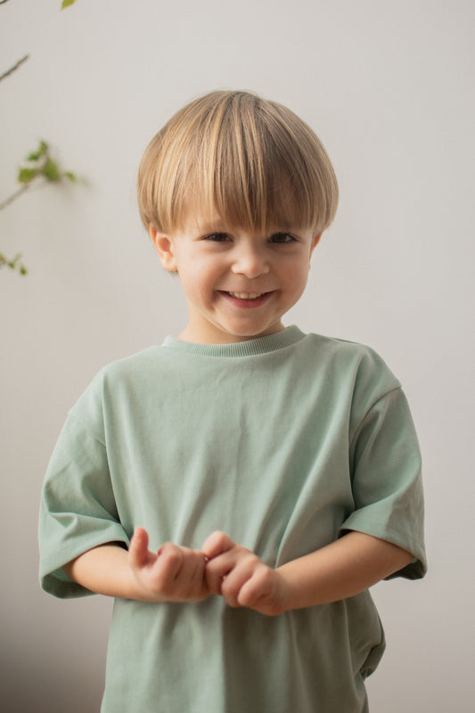 Discover our oversized Grow-With-Me T-Shirt – a gender-neutral, eco-friendly essential for kids. Handmade in Montreal, designed for comfort and longevity.
