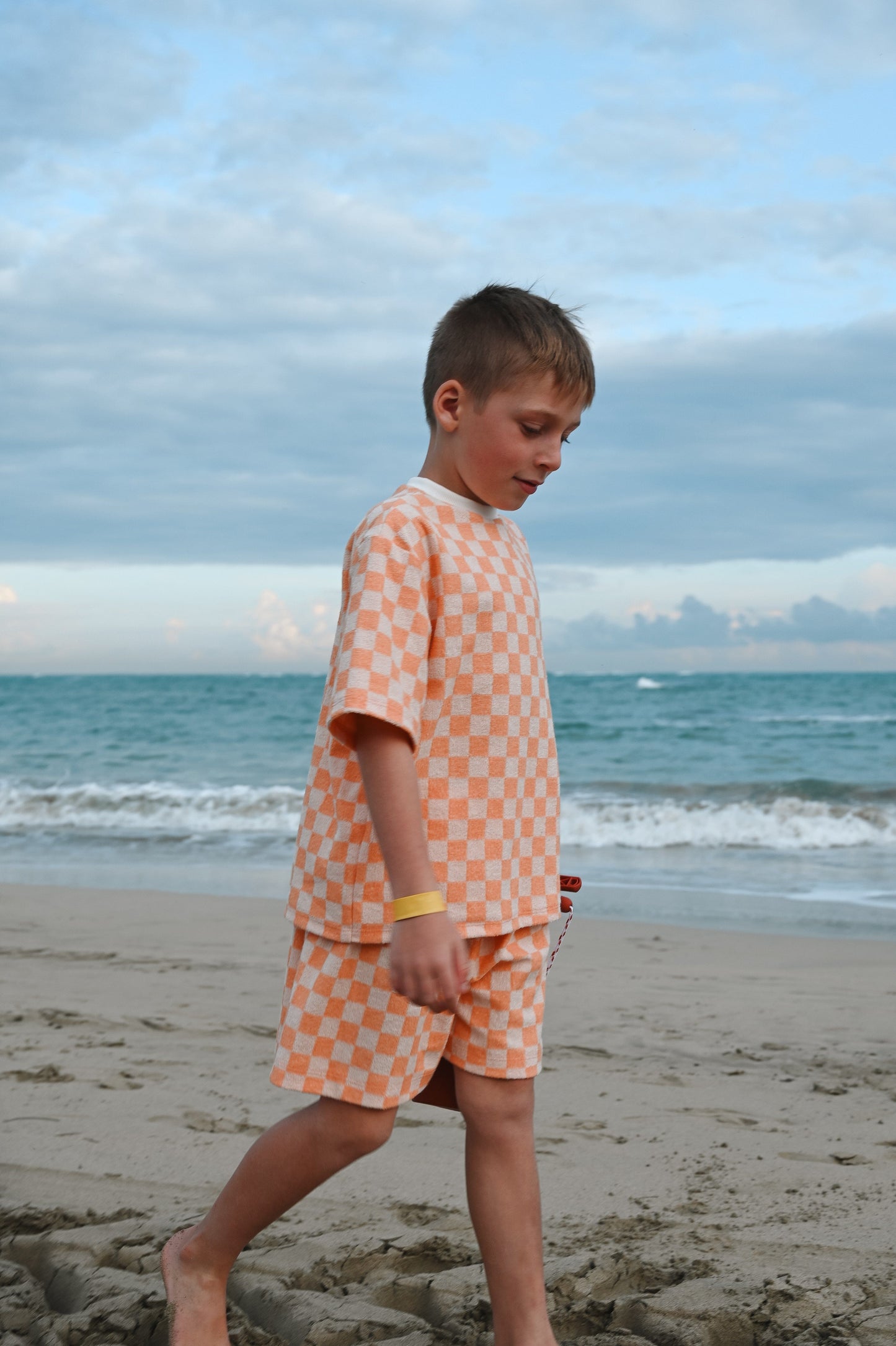 Checkered orange loose kids short made in Canada with eco-friendly fabric designed to grow with your child