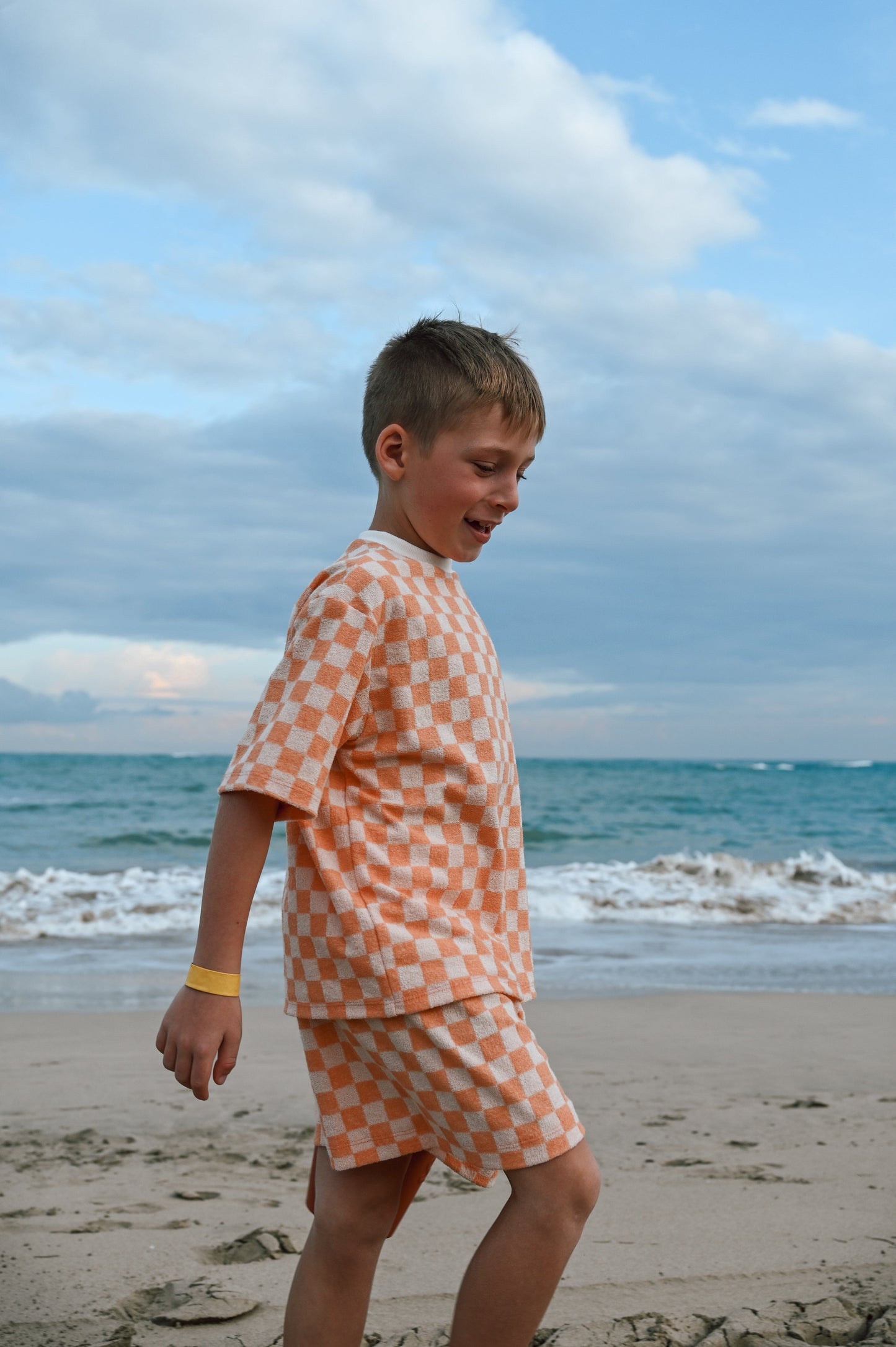 Checkered orange loose kids short made in Canada with eco-friendly fabric designed to grow with your child