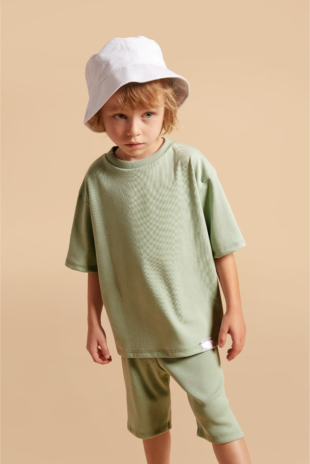 Discover our oversized Grow-With-Me T-Shirt – a gender-neutral, eco-friendly essential for kids. Handmade in Montreal, designed for comfort and longevity.