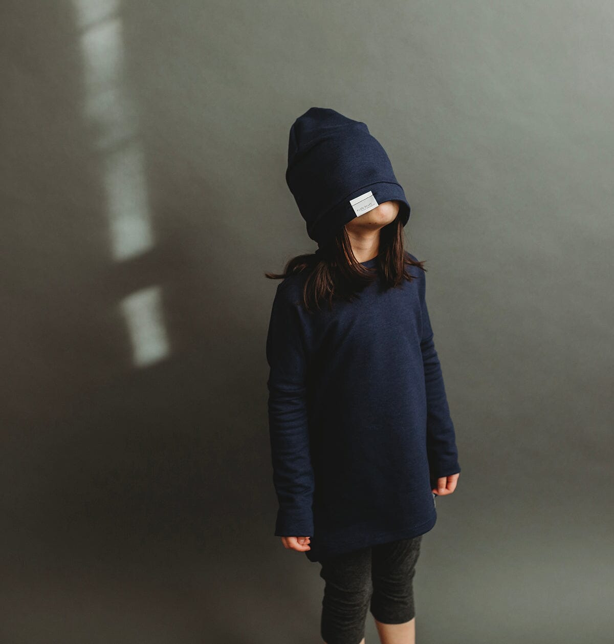 Soft and stretchy navy beanie for kids, made from eco-friendly fabric. Ethically crafted in Canada, featuring a fold-over brim and minimalist design