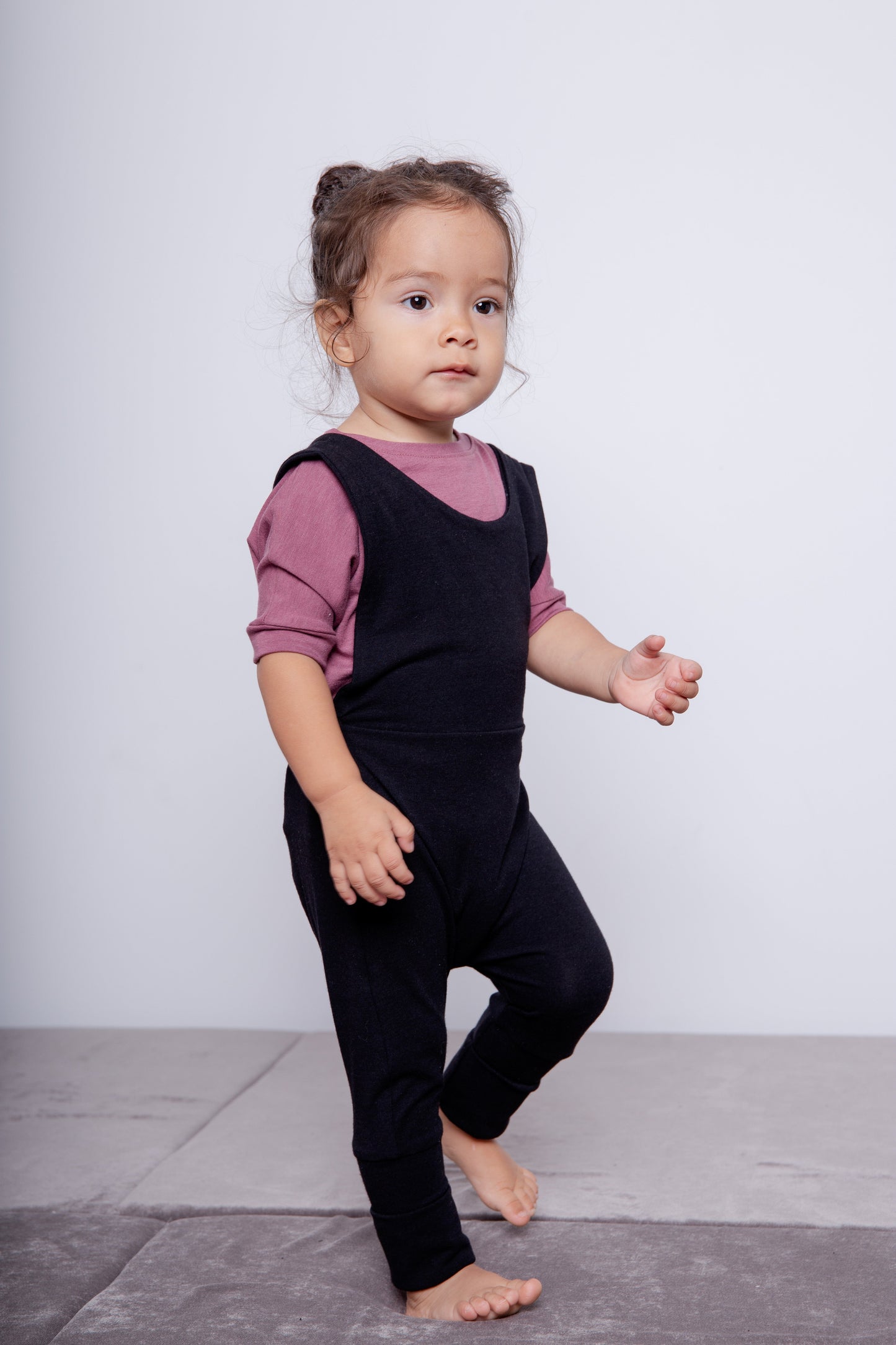 black grow-with-me overalls for toddlers and kids, made from soft, eco-friendly fabric. Adjustable straps and cuffs for a long-lasting fit. Ethically made in Canada.