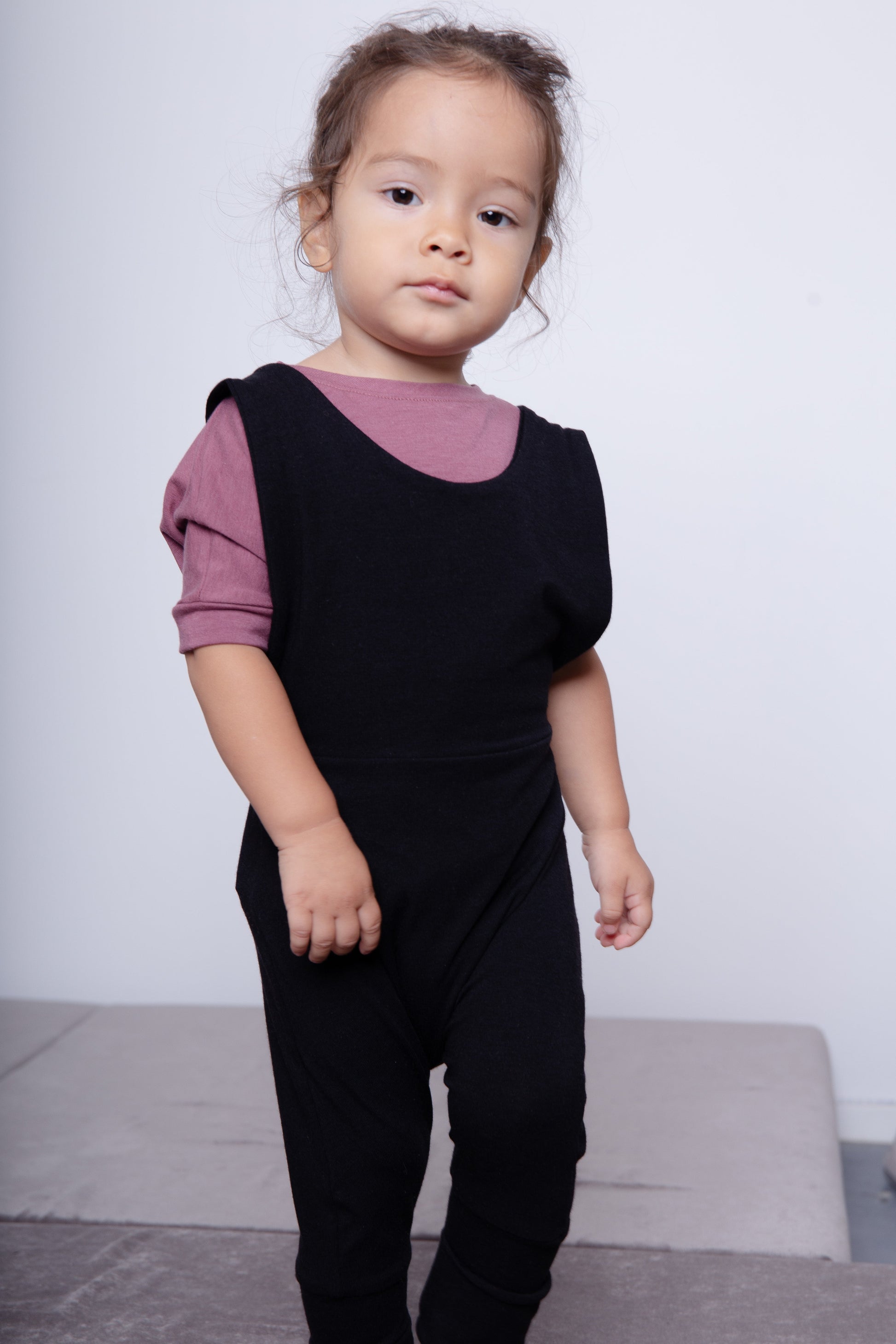 black grow-with-me overalls for toddlers and kids, made from soft, eco-friendly fabric. Adjustable straps and cuffs for a long-lasting fit. Ethically made in Canada.